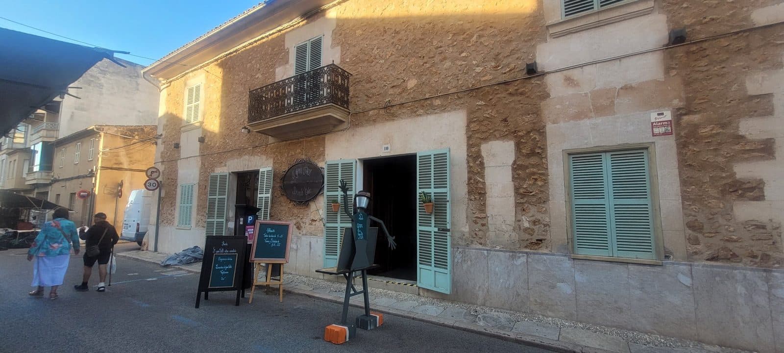 The front of El Gran Pati, a stone house with pale green shutters at number 10, Carrer de Santanyí, Campos